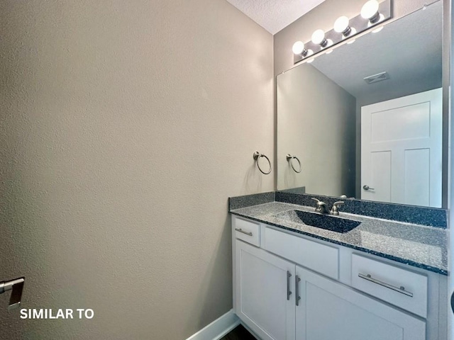 bathroom with a textured ceiling and vanity