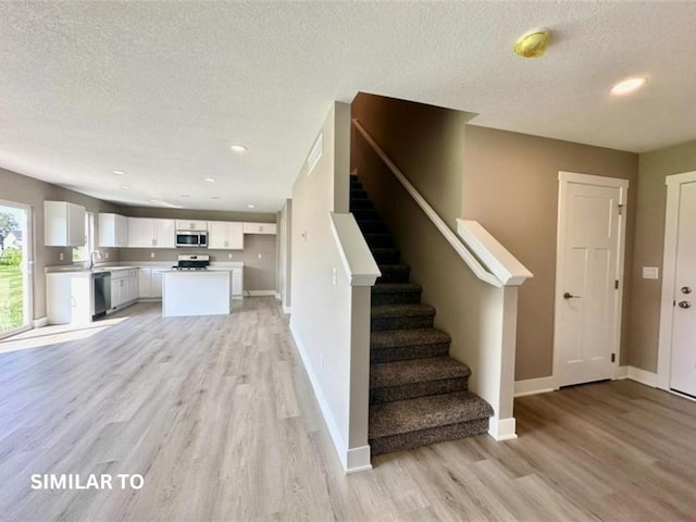 staircase with hardwood / wood-style flooring and a textured ceiling