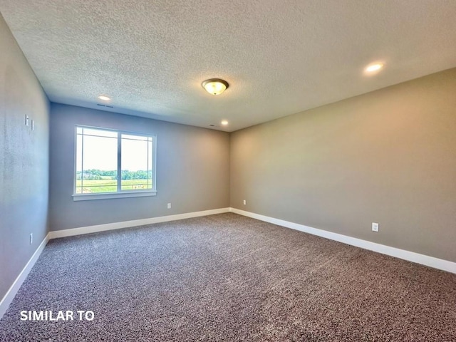 spare room with carpet flooring and a textured ceiling