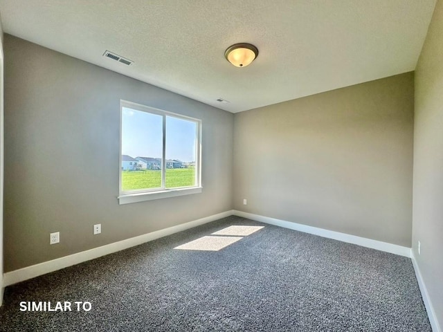 spare room featuring carpet floors and a textured ceiling