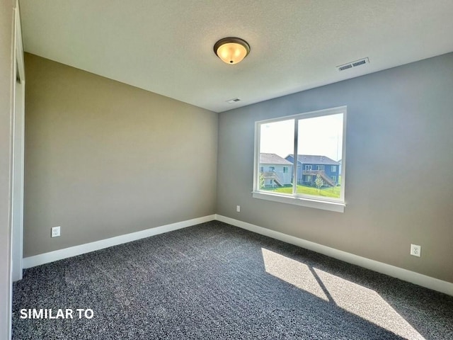 spare room featuring a textured ceiling and carpet floors