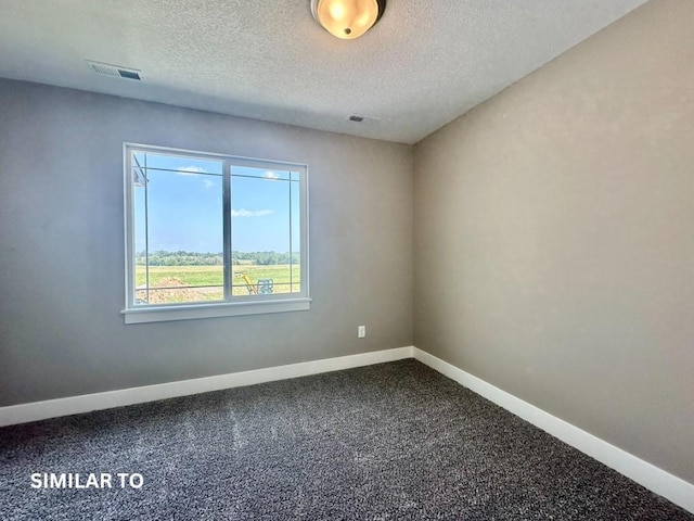 carpeted empty room with a textured ceiling