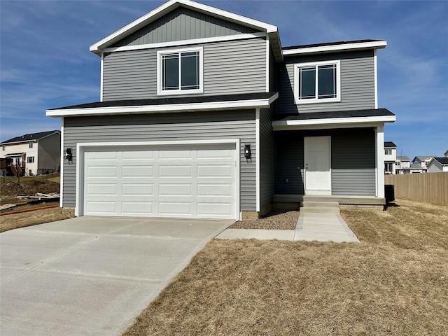 traditional-style home featuring fence, a garage, and driveway