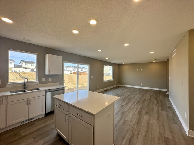 kitchen featuring visible vents, dishwasher, light countertops, and a sink