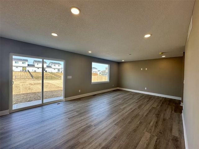 spare room with visible vents, baseboards, recessed lighting, a textured ceiling, and dark wood-style flooring