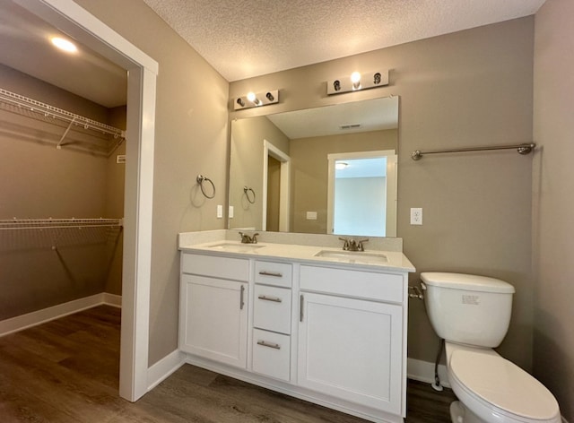 bathroom featuring toilet, wood finished floors, and a sink