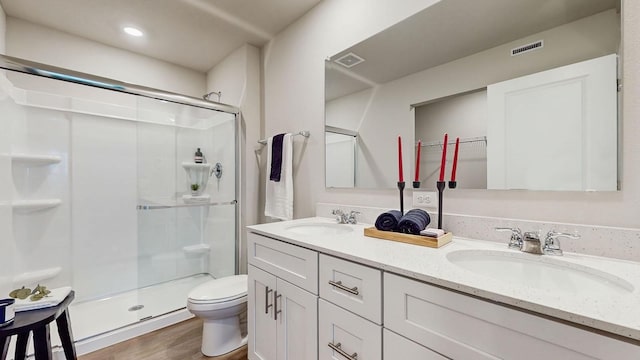 bathroom with toilet, wood-type flooring, a shower with door, and vanity