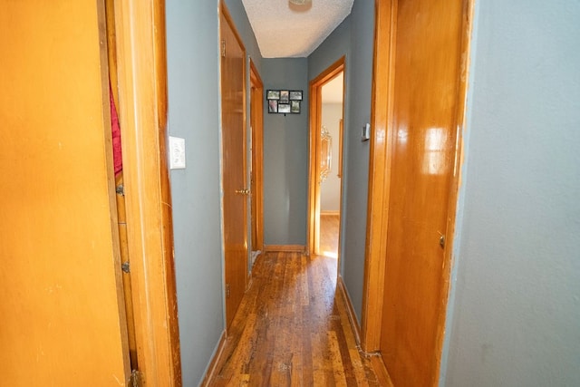 hall featuring dark hardwood / wood-style flooring and a textured ceiling