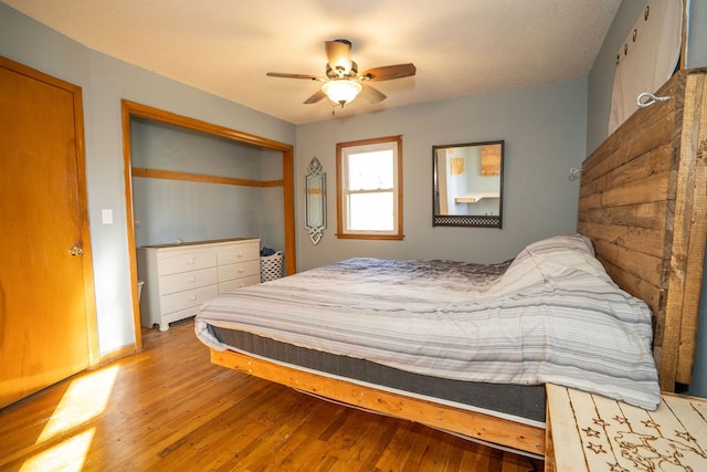 bedroom featuring wood-type flooring, ceiling fan, and a textured ceiling