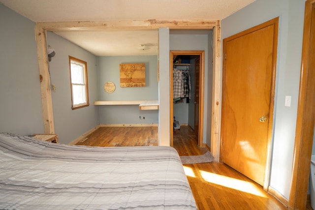 unfurnished bedroom with hardwood / wood-style flooring, a closet, and built in desk