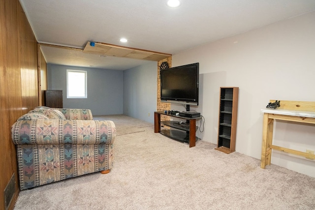 living room featuring wooden walls and light colored carpet