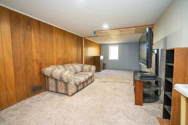 carpeted living room with wood walls