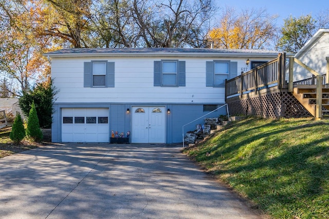 view of front of house featuring a garage, a wooden deck, and a front yard