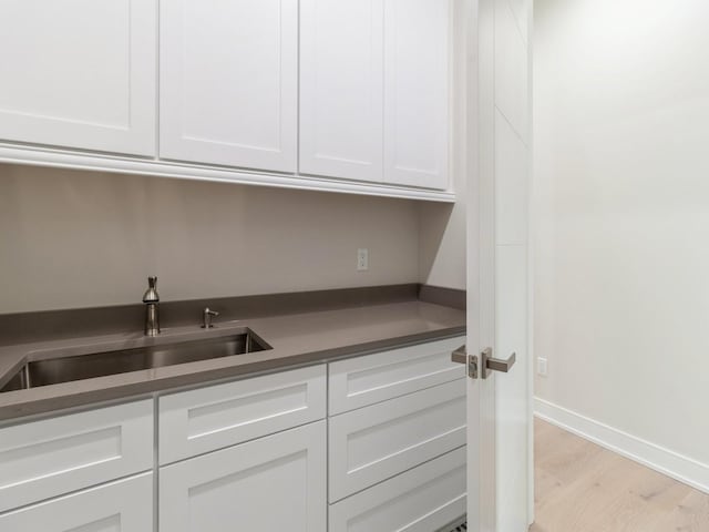 18176 Alderleaf Dr, Clive, IA 50325 - kitchen with light wood-type flooring, a sink, white cabinetry, and baseboards