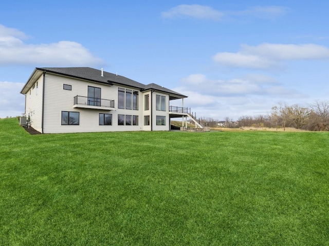 18176 Alderleaf Dr, Clive, IA 50325 - rear view of house with a balcony, central AC unit, a yard, and stairs
