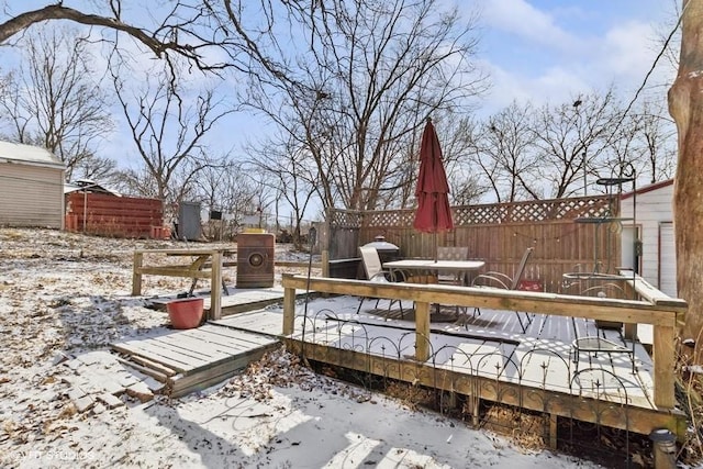 snow covered patio featuring a wooden deck