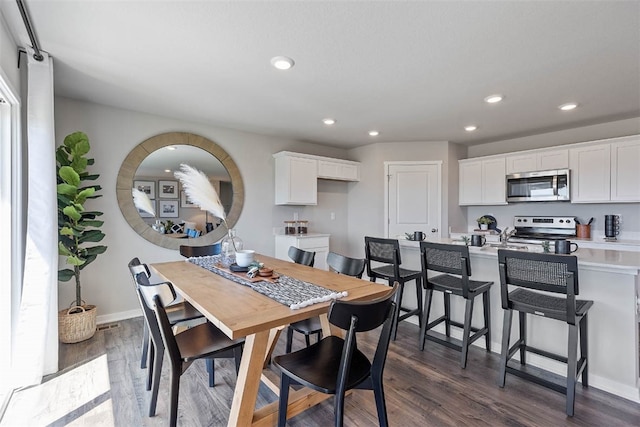 dining space featuring baseboards, dark wood-type flooring, and recessed lighting