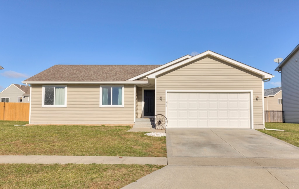 single story home featuring a garage and a front lawn