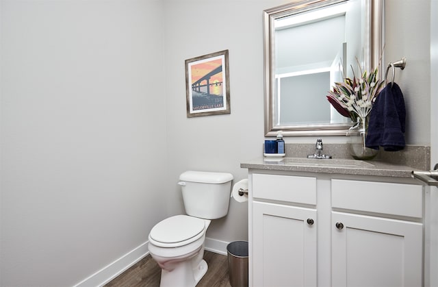 bathroom with hardwood / wood-style flooring, vanity, and toilet