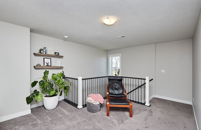 sitting room with carpet floors and a textured ceiling