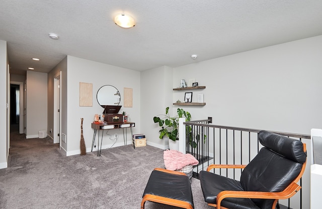 sitting room featuring a textured ceiling and carpet