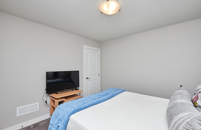 carpeted bedroom featuring a textured ceiling