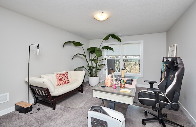 carpeted home office featuring a textured ceiling