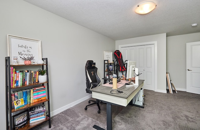 carpeted home office featuring a textured ceiling