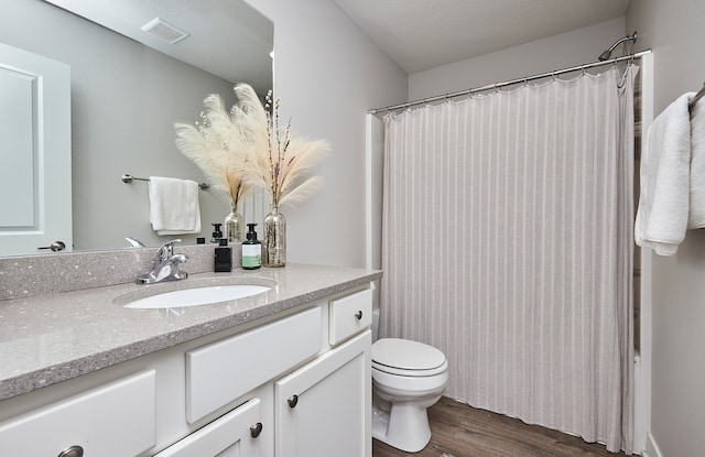 bathroom with toilet, vanity, and wood-type flooring