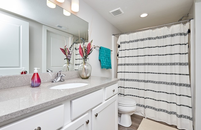 bathroom featuring a shower with curtain, wood-type flooring, vanity, and toilet