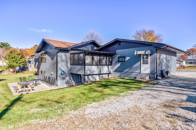 back of property featuring a lawn and a patio area