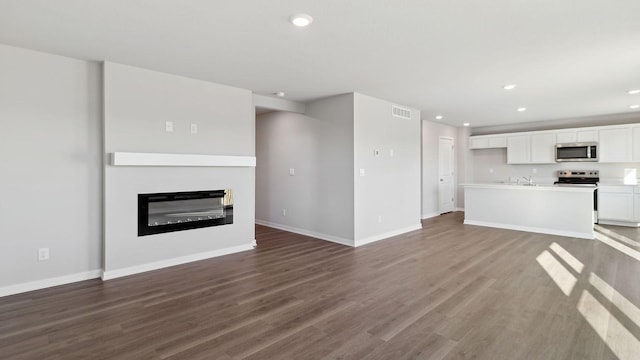 unfurnished living room featuring dark hardwood / wood-style flooring