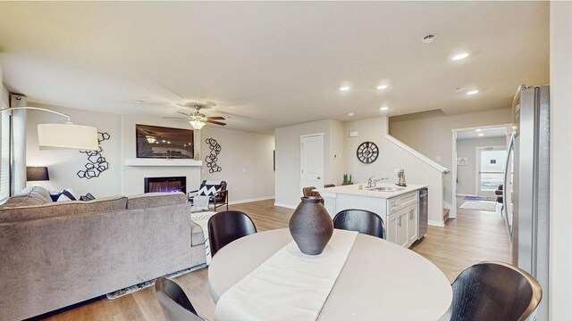 1007 Daisy Ln, Waukee, IA 50263 - dining area featuring ceiling fan, sink, and light hardwood / wood-style flooring