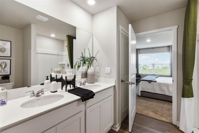 bathroom featuring vanity, wood-type flooring, and toilet