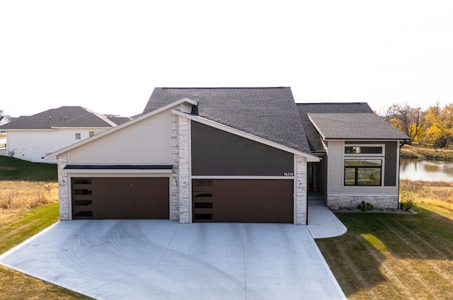 view of front of house with a front lawn and a water view