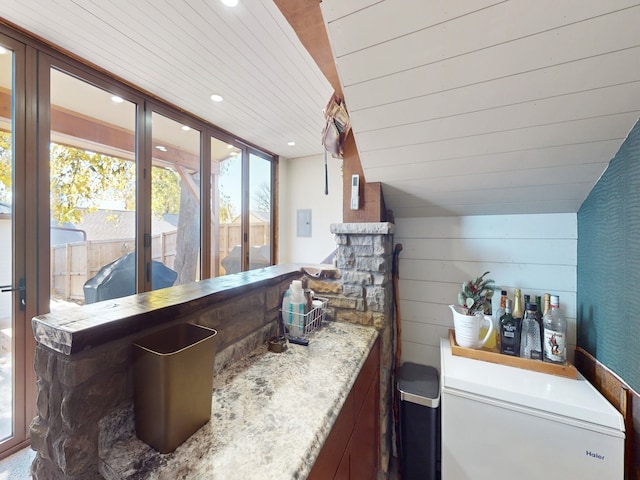 bar with fridge, wooden walls, vaulted ceiling, and wood ceiling