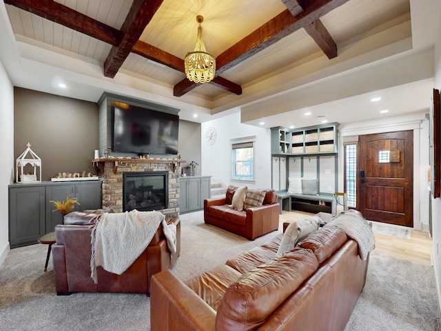 living room with wooden ceiling, light hardwood / wood-style floors, beam ceiling, a stone fireplace, and a notable chandelier