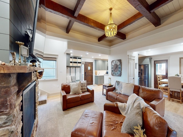 living room with a fireplace, light wood-type flooring, a wealth of natural light, and beam ceiling