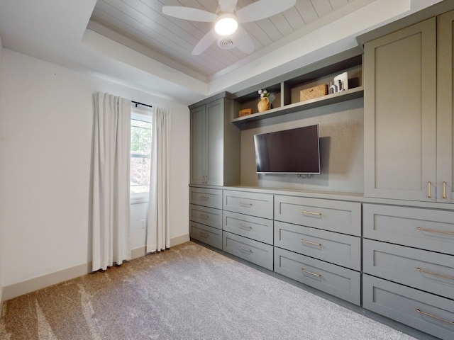 unfurnished bedroom with light colored carpet, ceiling fan, and a raised ceiling