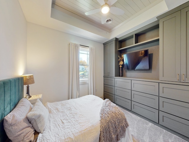 bedroom with carpet flooring, wood ceiling, ceiling fan, and a tray ceiling