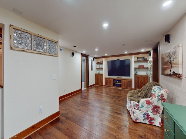 living room featuring built in shelves and dark hardwood / wood-style floors