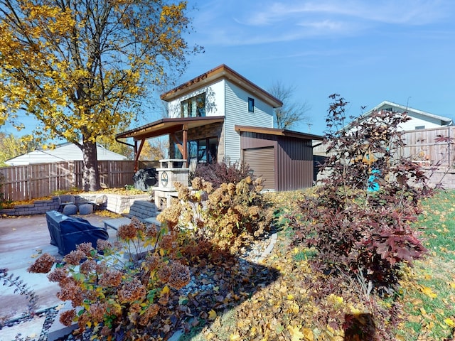 back of house with a patio area and a shed