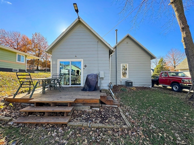 rear view of house with a deck and a yard