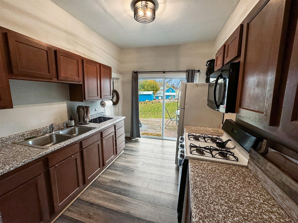 kitchen featuring dark hardwood / wood-style floors, white gas range, and sink