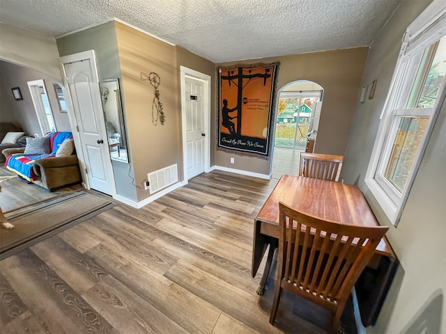 dining room with hardwood / wood-style floors and a textured ceiling