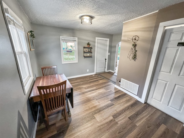 dining area with hardwood / wood-style floors and a textured ceiling