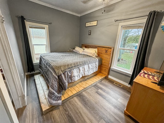 bedroom featuring ceiling fan, ornamental molding, and dark wood-type flooring