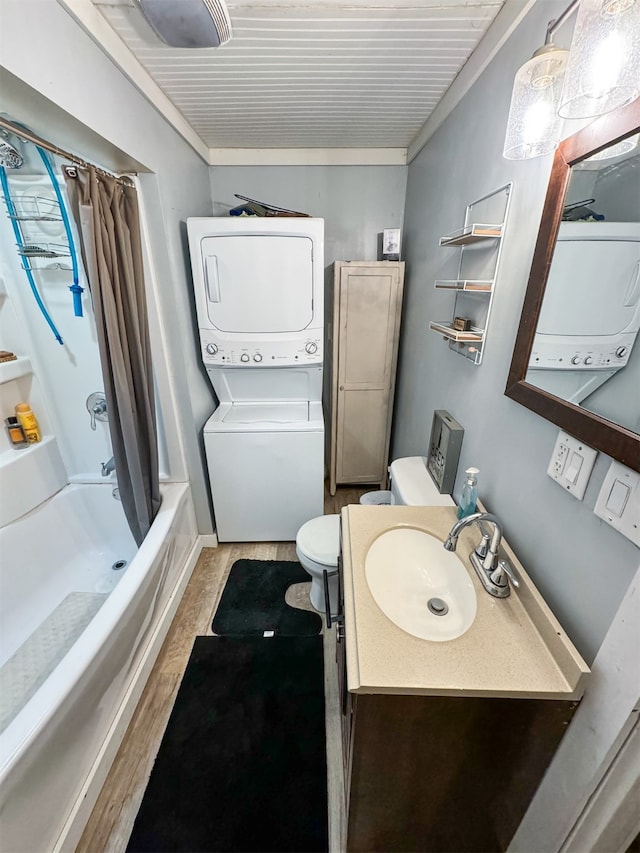 full bathroom with hardwood / wood-style floors, vanity, stacked washer and clothes dryer, toilet, and shower / bath combo with shower curtain