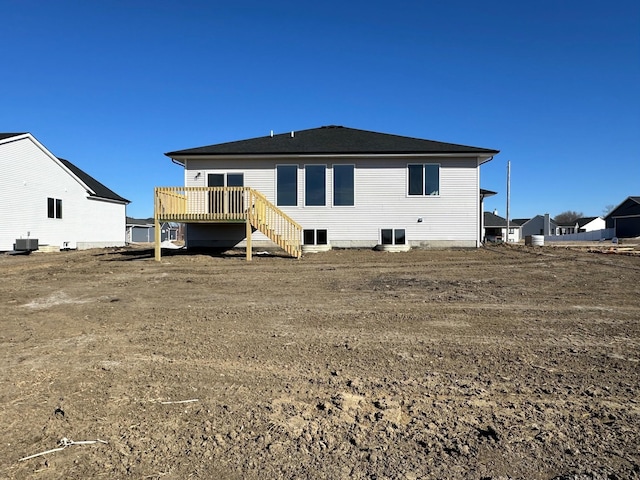 back of property with cooling unit, a wooden deck, and stairs