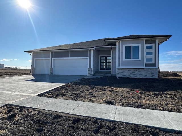 view of front of house featuring stone siding, concrete driveway, and an attached garage